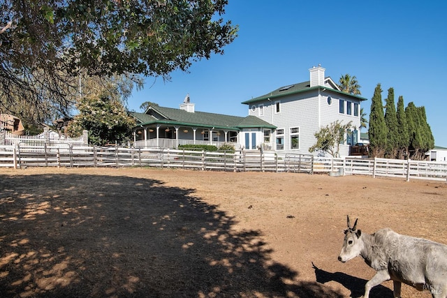 rear view of house featuring fence and a chimney