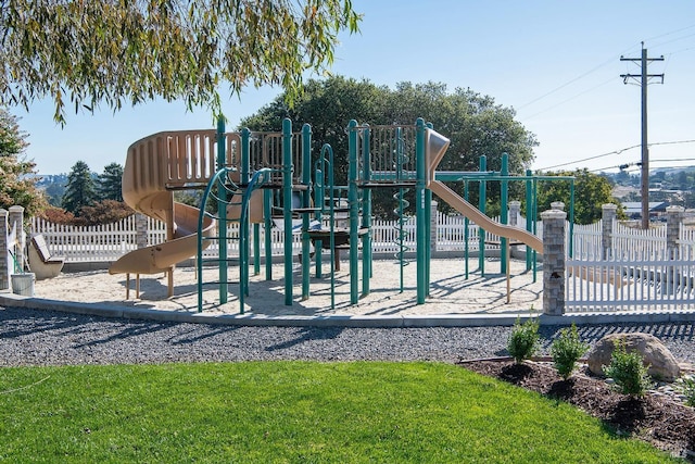 community play area with fence and a lawn