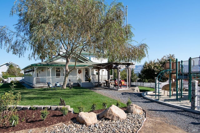 exterior space featuring covered porch, a lawn, playground community, and fence