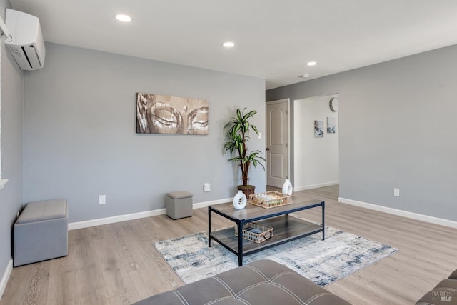 living area featuring a wall mounted air conditioner and light hardwood / wood-style flooring