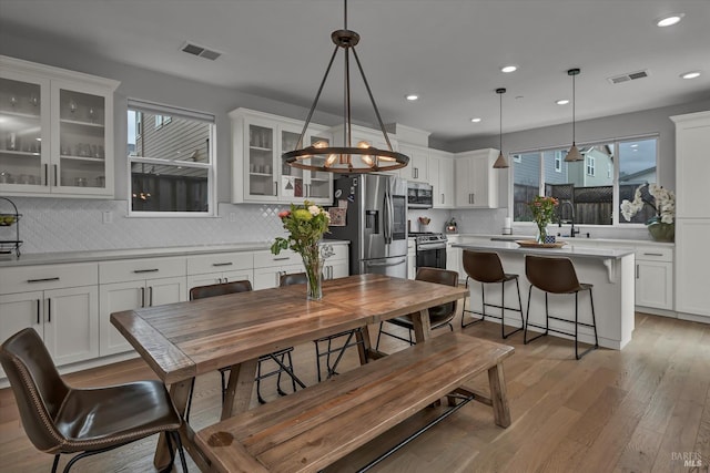 dining space with sink and light hardwood / wood-style floors