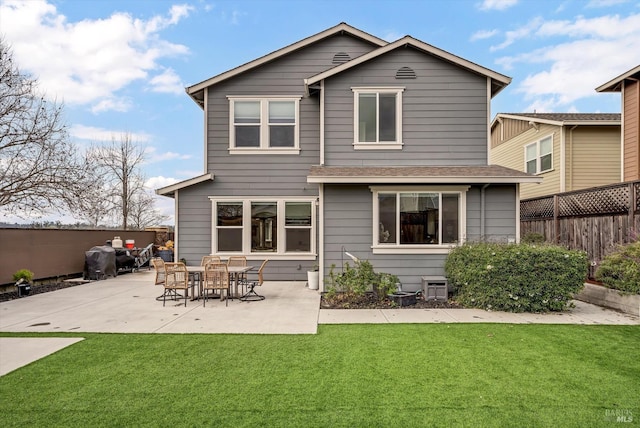 back of property with a patio area and a lawn