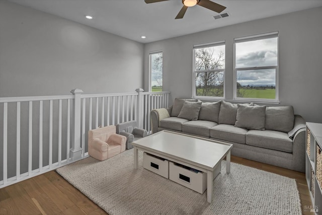 living room featuring wood-type flooring and ceiling fan