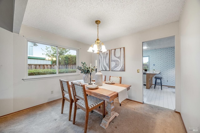 dining space featuring a notable chandelier, a textured ceiling, and carpet flooring