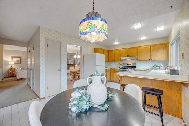 carpeted dining room with sink and a textured ceiling