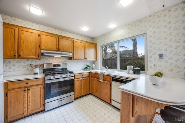 kitchen featuring sink, white dishwasher, kitchen peninsula, and gas stove