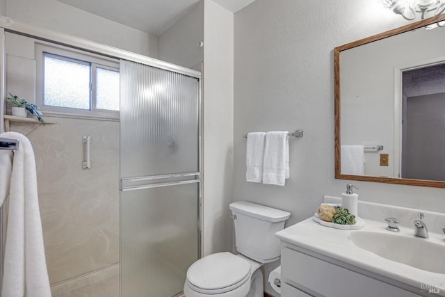 bathroom featuring vanity, toilet, and a shower with shower door