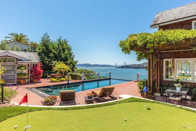 pool featuring a patio area and a water view