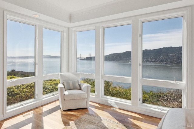 sunroom / solarium with a water view and visible vents