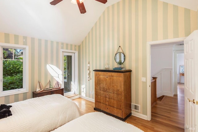 bedroom with access to exterior, vaulted ceiling, light hardwood / wood-style floors, and ceiling fan