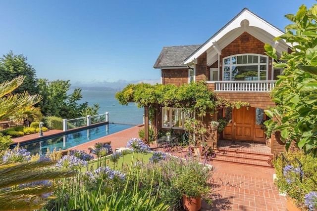 exterior space with a water view and an outdoor pool