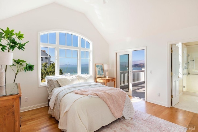 bedroom with access to outside, vaulted ceiling, and light wood-style flooring