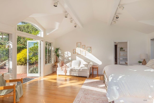 bedroom with lofted ceiling, track lighting, access to exterior, and light hardwood / wood-style floors