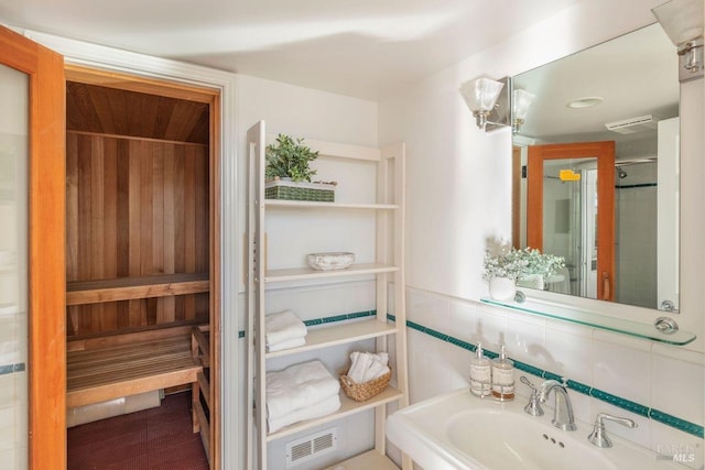 bathroom featuring tile walls, sink, and backsplash