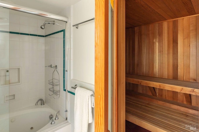 bathroom with tiled shower / bath combo and radiator heating unit