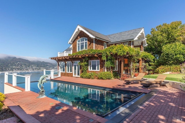 outdoor pool featuring a patio, a storage structure, and a mountain view