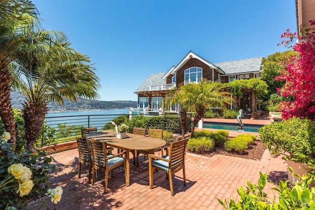 view of patio / terrace with a water view and a balcony