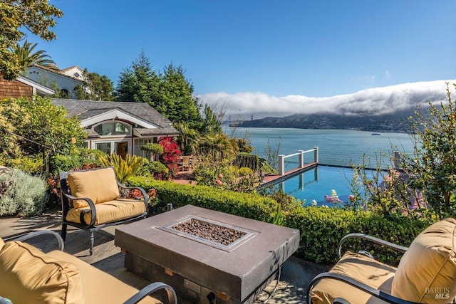 view of patio with a water view and an outdoor fire pit