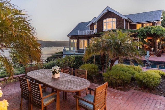 patio terrace at dusk with a balcony and a water view