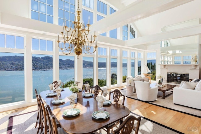 sunroom with an inviting chandelier and a water and mountain view