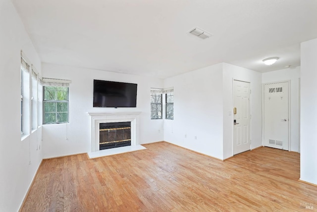 unfurnished living room featuring a healthy amount of sunlight and light wood-type flooring