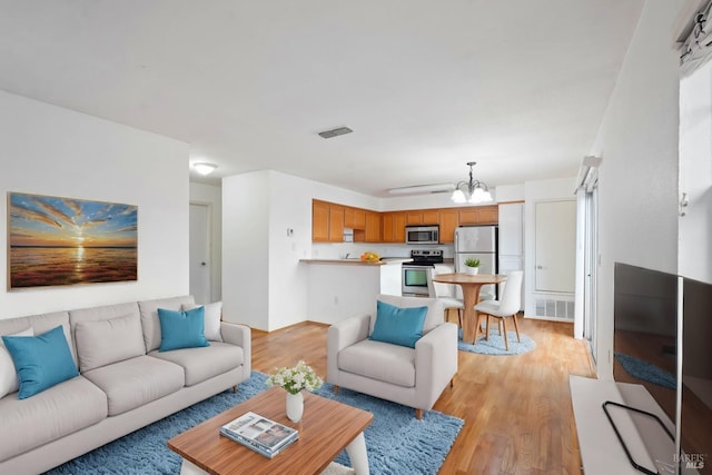 living room featuring light hardwood / wood-style flooring and a notable chandelier