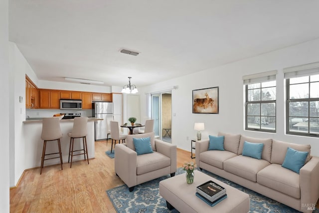 living room featuring a notable chandelier and light hardwood / wood-style flooring