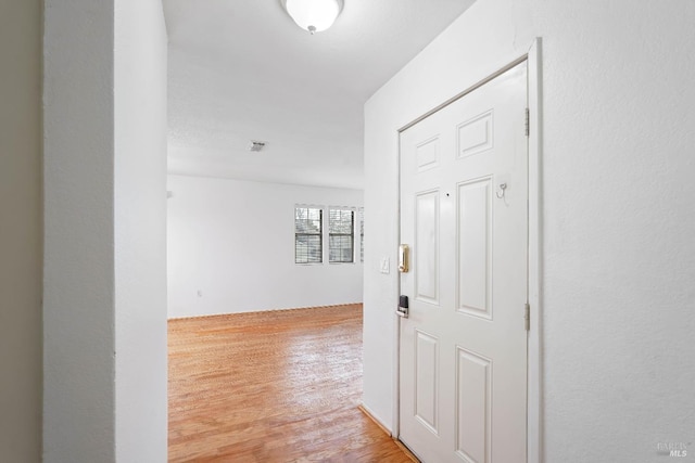 corridor with light hardwood / wood-style floors