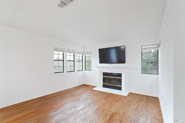 unfurnished living room with plenty of natural light and light hardwood / wood-style floors