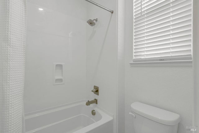 bathroom featuring shower / tub combo and toilet