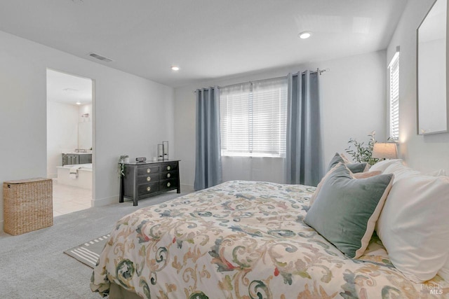 bedroom featuring light carpet and ensuite bath