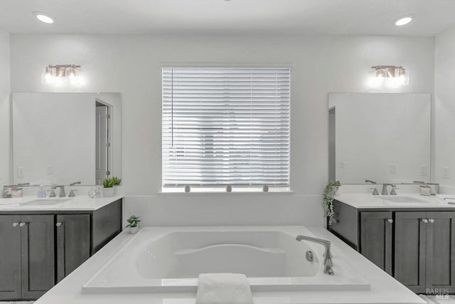 bathroom with vanity and a washtub