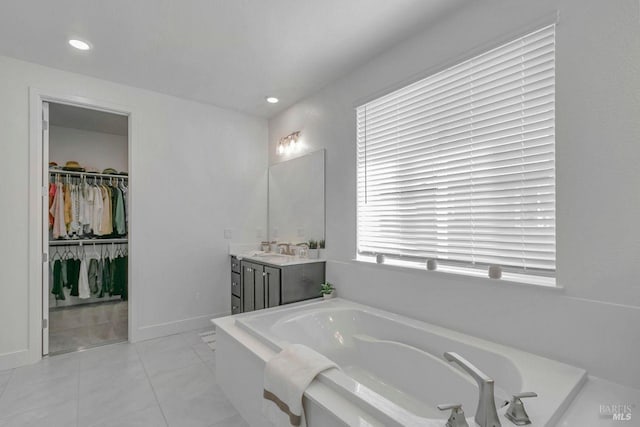 bathroom with vanity, a washtub, and tile patterned floors