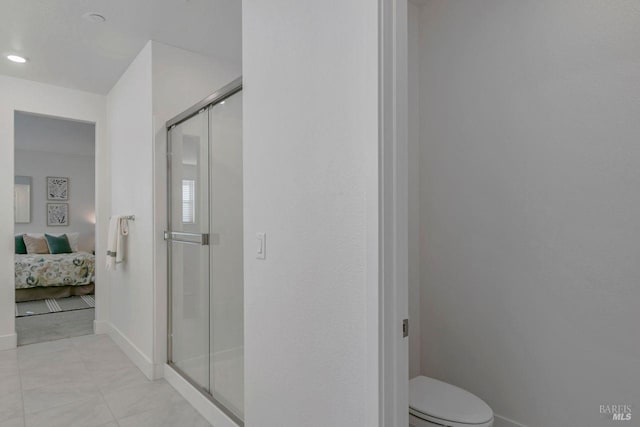 bathroom featuring toilet, tile patterned flooring, and a shower with door