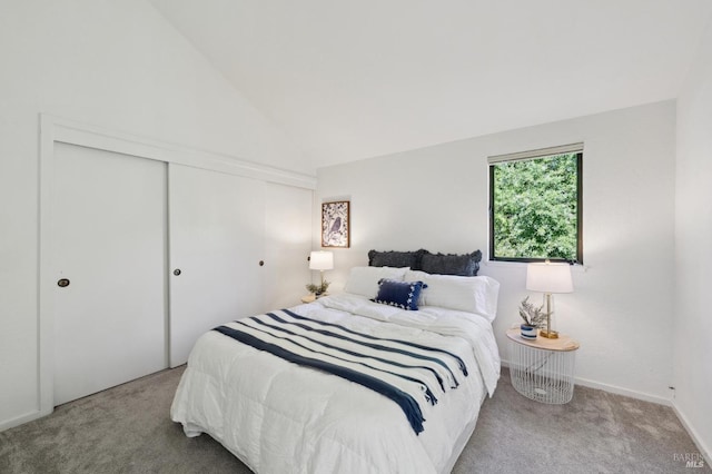 carpeted bedroom with vaulted ceiling and a closet