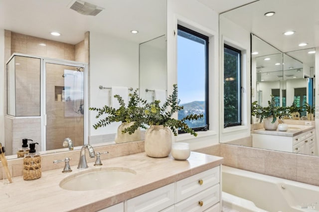 bathroom with shower with separate bathtub, plenty of natural light, and vanity