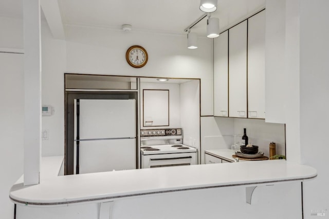 kitchen featuring white appliances, track lighting, and white cabinets