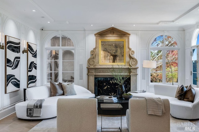 living room with crown molding, parquet flooring, and a premium fireplace