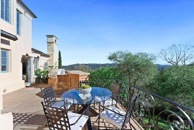balcony featuring an outdoor kitchen, a grill, and a patio area