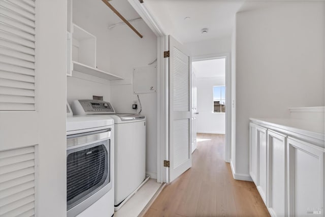 laundry room featuring washer and clothes dryer and light hardwood / wood-style floors