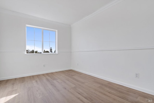 empty room with ornamental molding and light hardwood / wood-style flooring