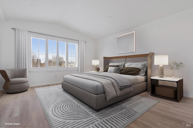 bedroom featuring light hardwood / wood-style floors and vaulted ceiling