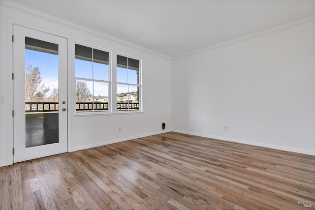 unfurnished room featuring ornamental molding and light wood-type flooring