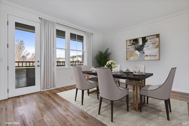 dining area with crown molding and light wood-type flooring