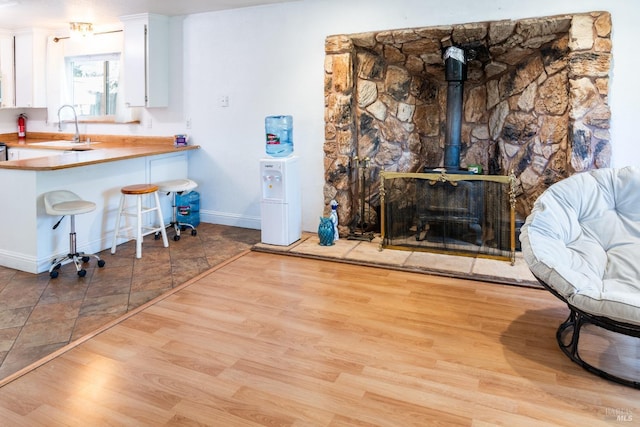 kitchen featuring sink, a breakfast bar area, white cabinets, light hardwood / wood-style floors, and kitchen peninsula