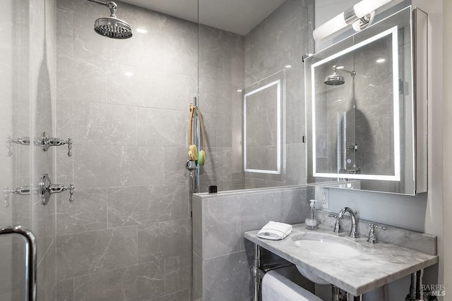 full bathroom with a tile shower and vanity