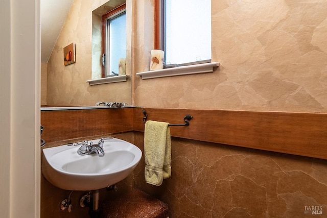 bathroom featuring lofted ceiling and a sink