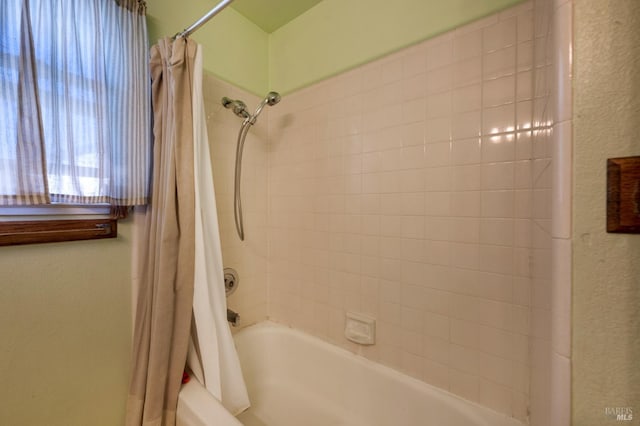 full bath with shower / bathtub combination with curtain and a textured wall