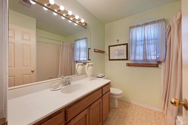 full bathroom featuring a shower with shower curtain, toilet, vanity, baseboards, and tile patterned floors