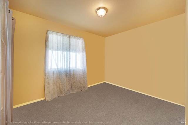 spare room with dark carpet and baseboards